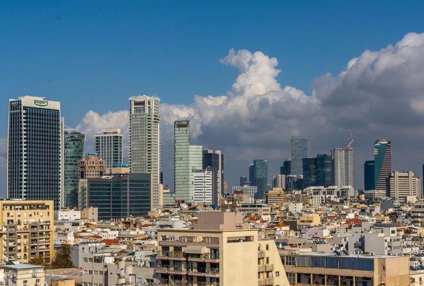 Buildings and skyscrapers against a cloudy and blue sky in Tel Aviv